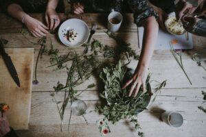 Women working with fresh herbs at wooden table
